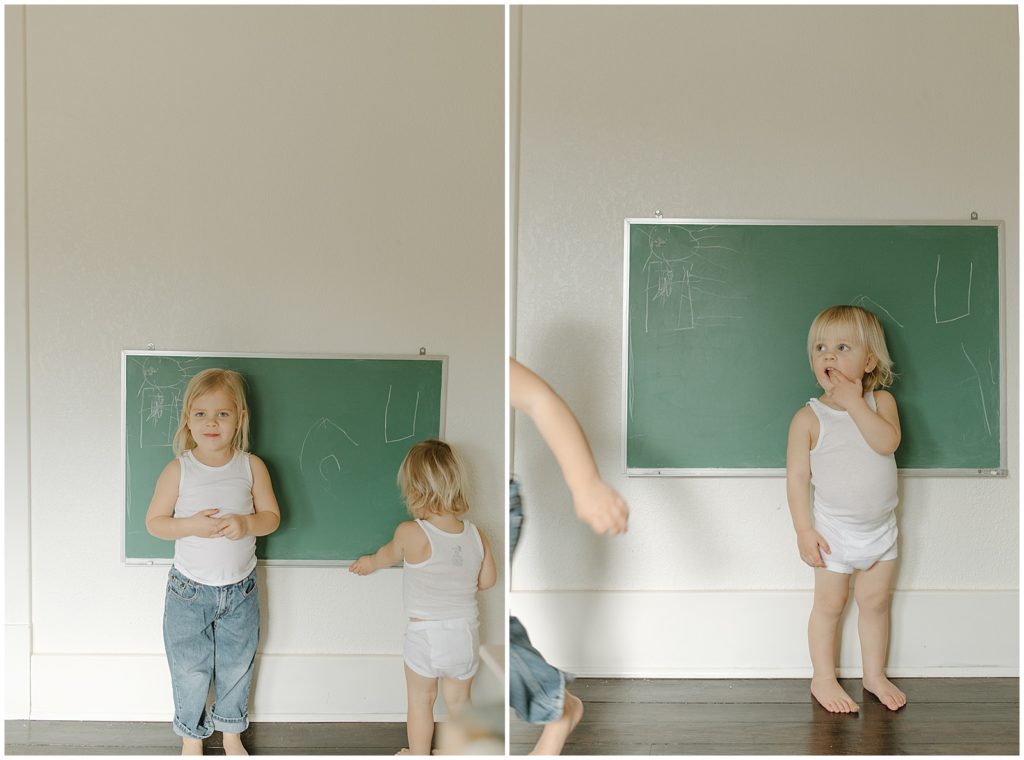 The children stand in front of a green chalkboard on the bedroom wall.