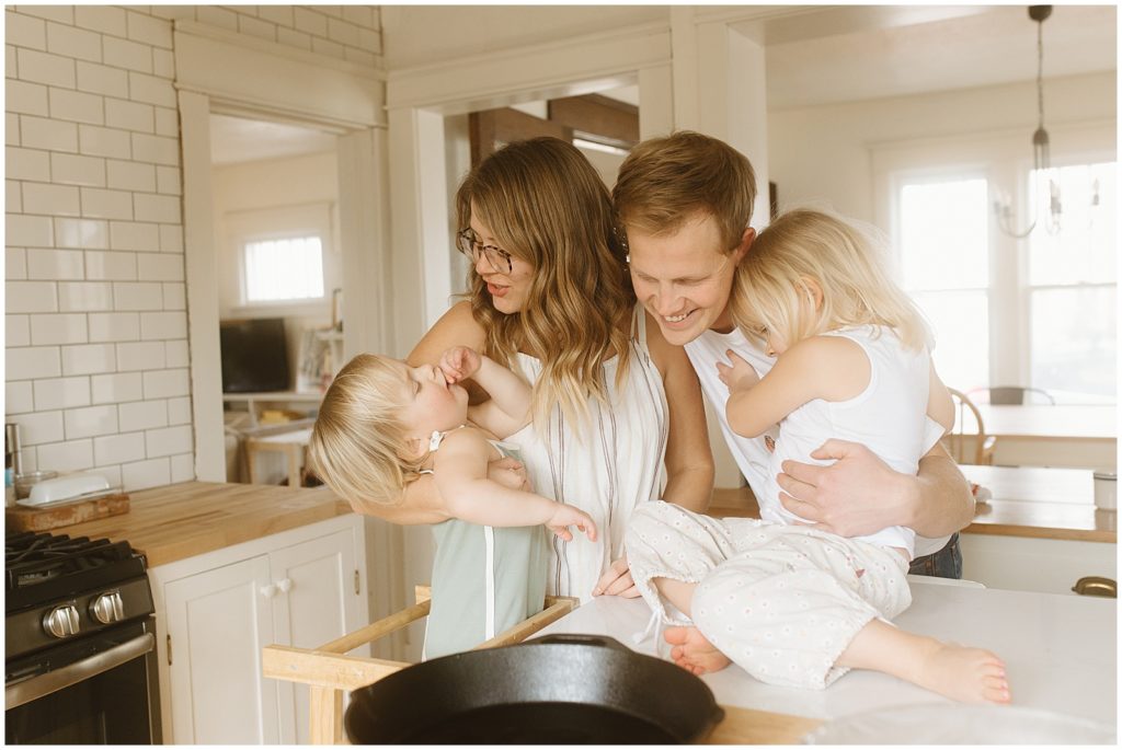 The family cuddles beside the stove and laughs.