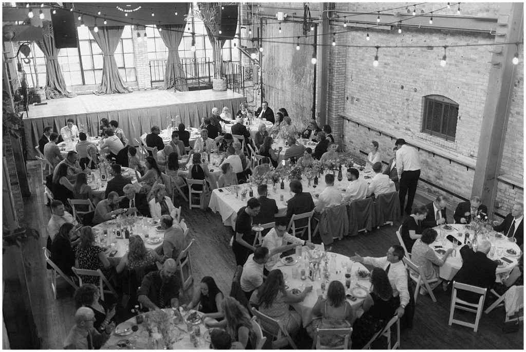 Wedding guests sit for dinner at The Cooperage.