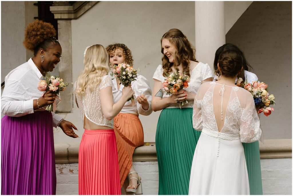 A bride and bridesmaids gather to talk.