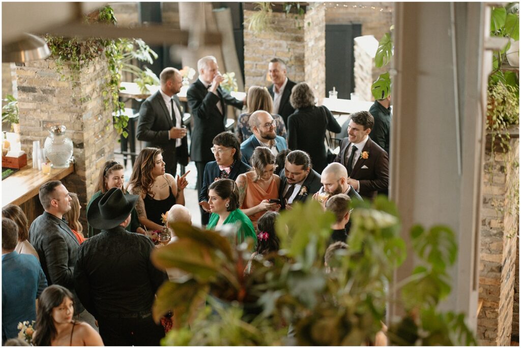Wedding guests drink cocktails in the garden of a Milwaukee wedding venue.