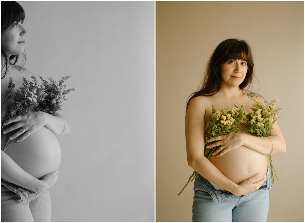 A pregnant woman poses for studio maternity photos with bouquets of flowers held against her bare chest.