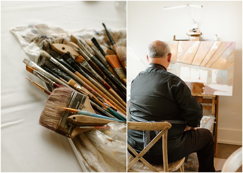 A wedding painter sits at an easel with a pile of brushes.