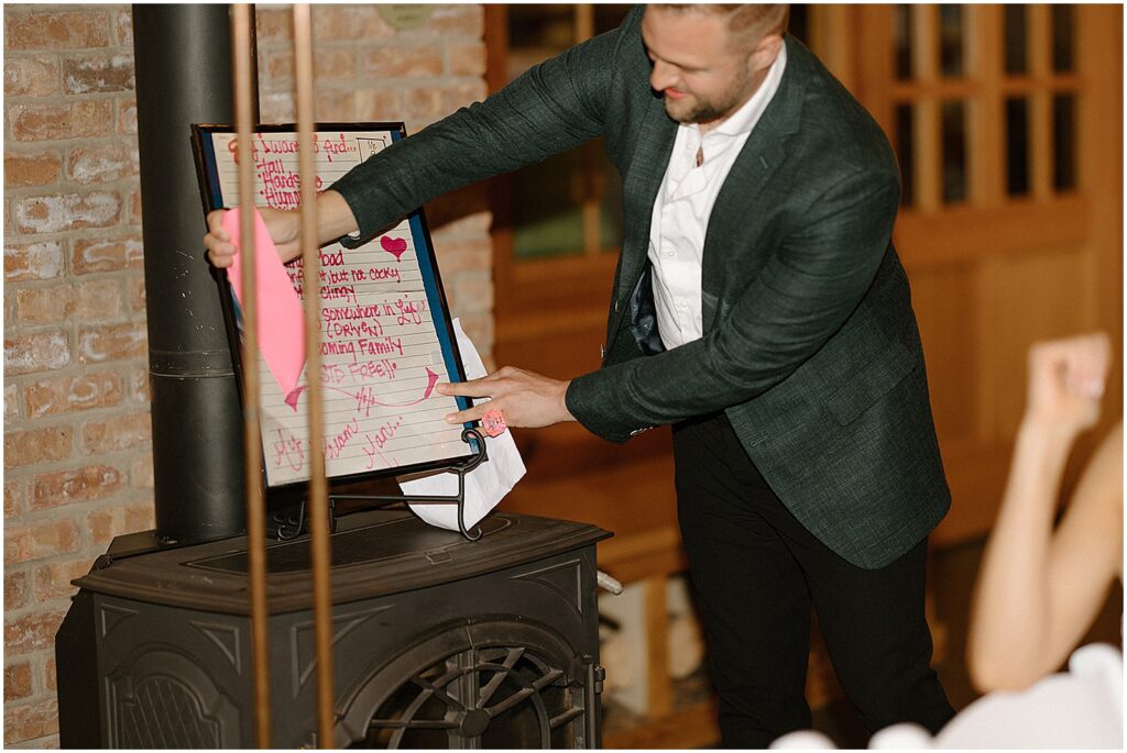 A groomsmen reveals a dry erase board during a wedding toast.