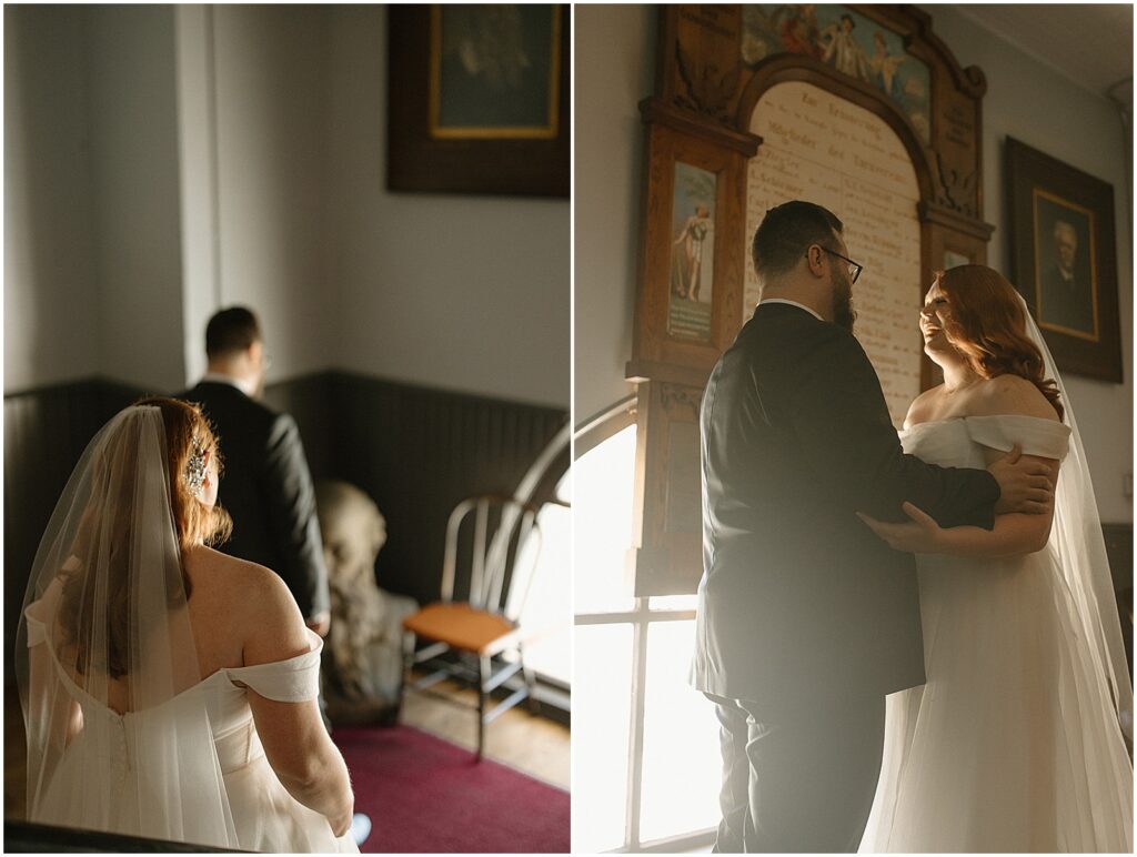 A bride and groom have their first look on a landing in front of a window at Turner Hall.