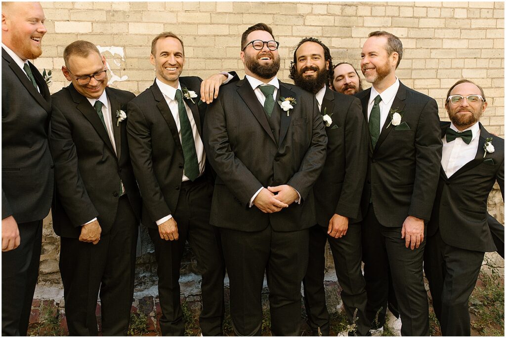 A groom poses with groomsmen outside a Milwaukee wedding venue.