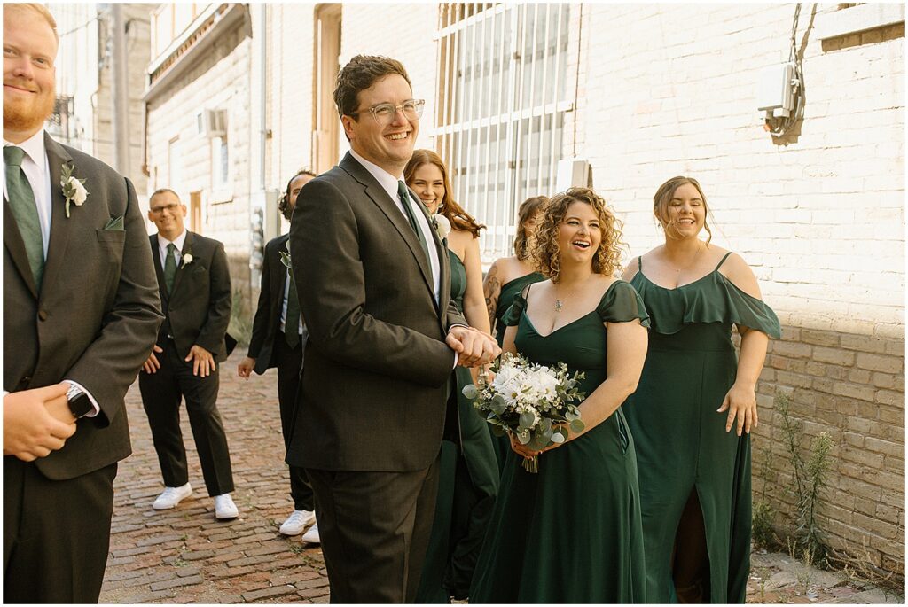 A wedding party laughs outside a Milwaukee wedding venue.