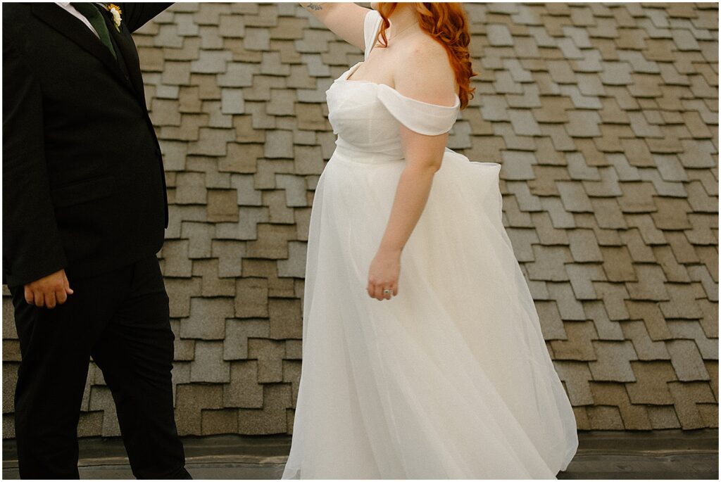A bride and groom dance on a Milwaukee rooftop in a candid wedding photo.