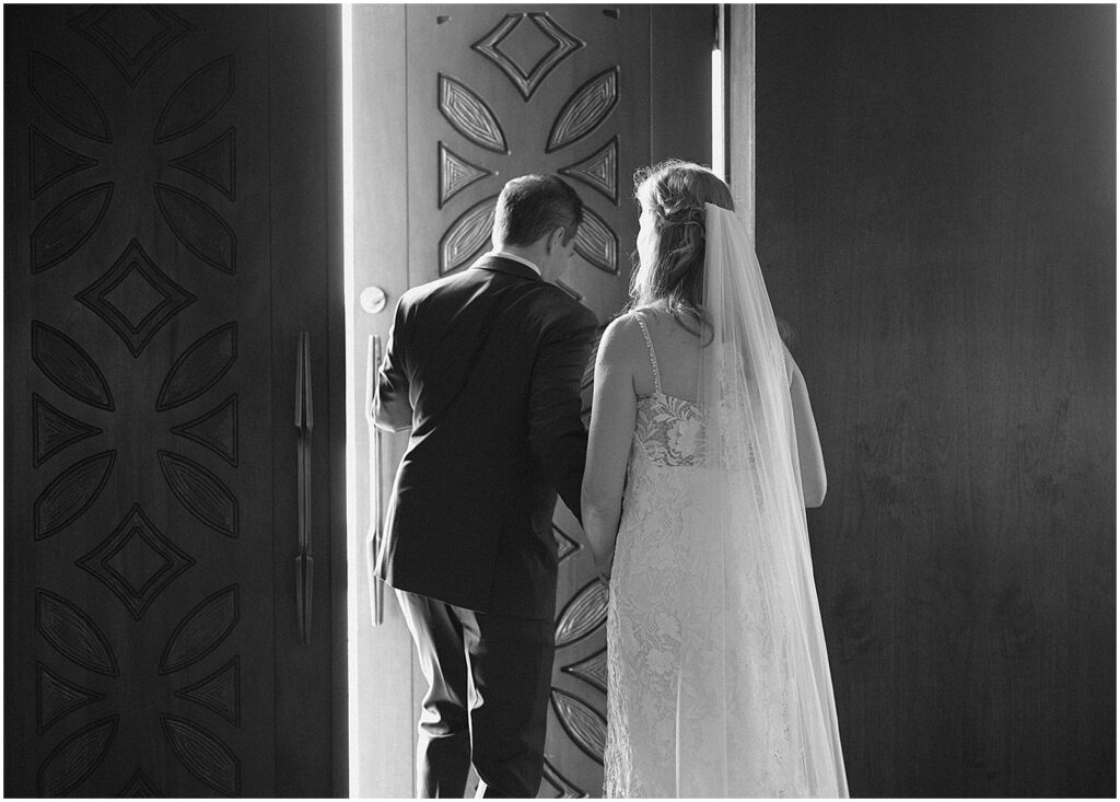 A Milwaukee bride and groom exit church doors after their wedding ceremony.