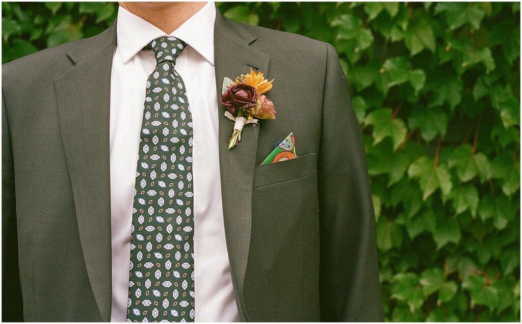 A groom shows off a colorful boutonniere.