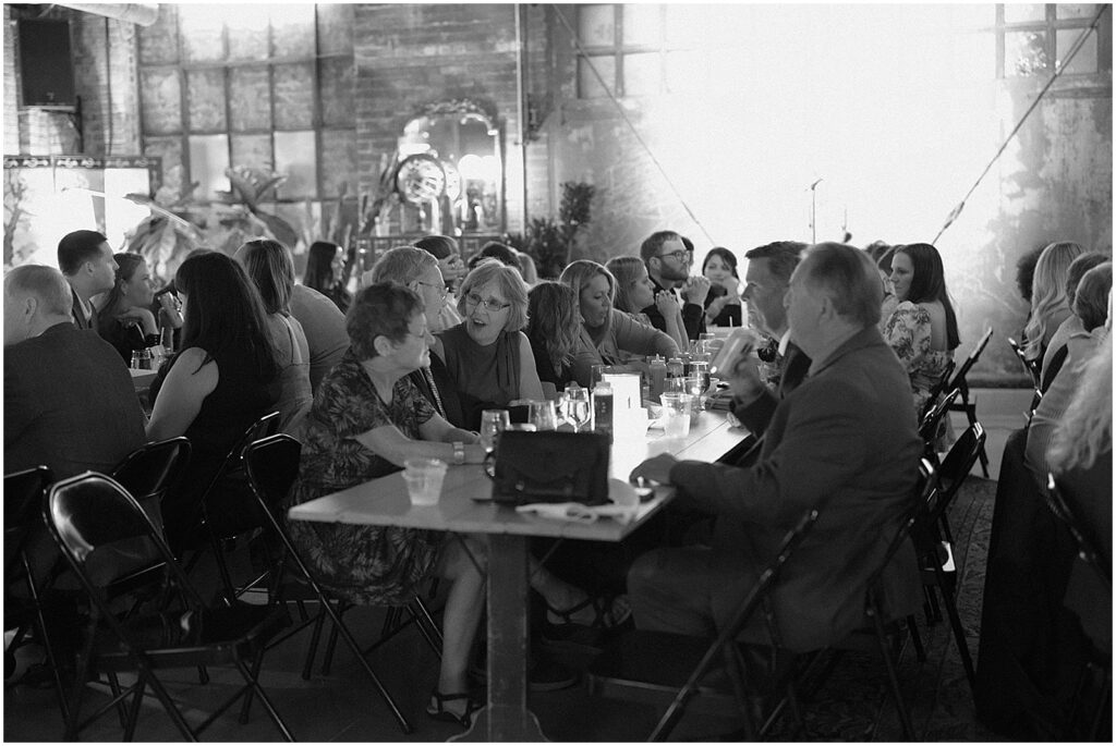 Wedding guests sit at long tables for a reception at Dandy Milwaukee.