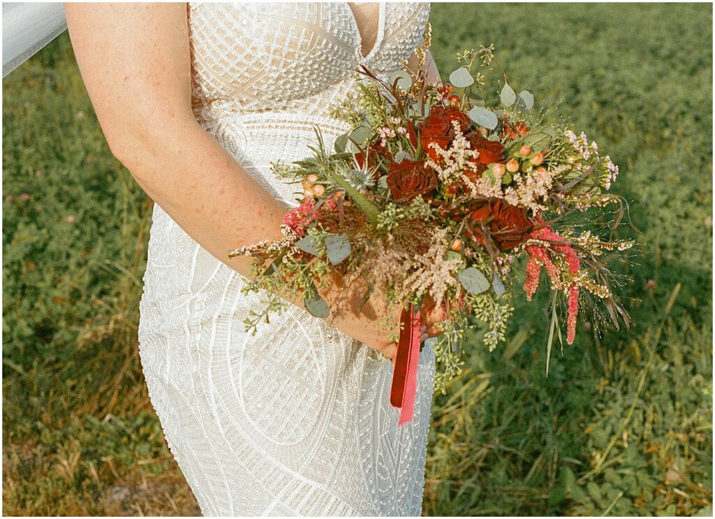 A bride olds a fall wedding bouquet.