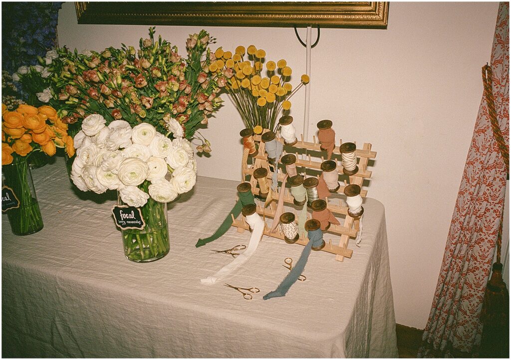 Spools of ribbon sit at the end of a bouquet bar.