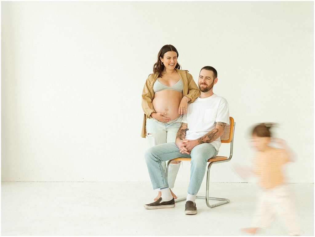 A toddler runs past her parents in a Milwaukee photography studio.