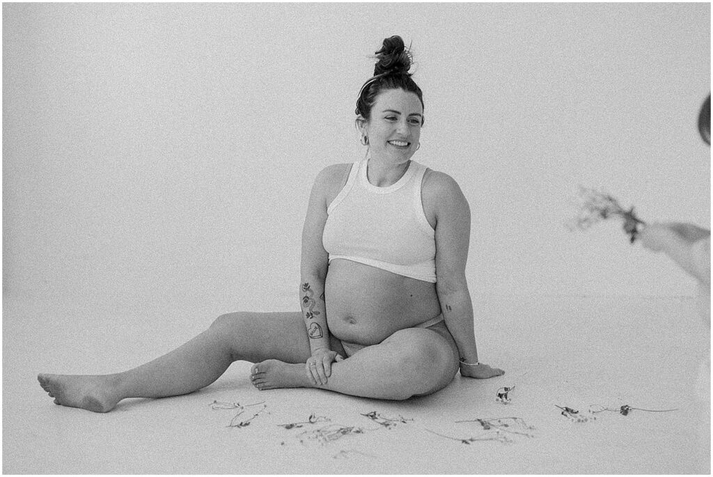 A pregnant woman sits on the floor of a Milwaukee studio during a maternity session.