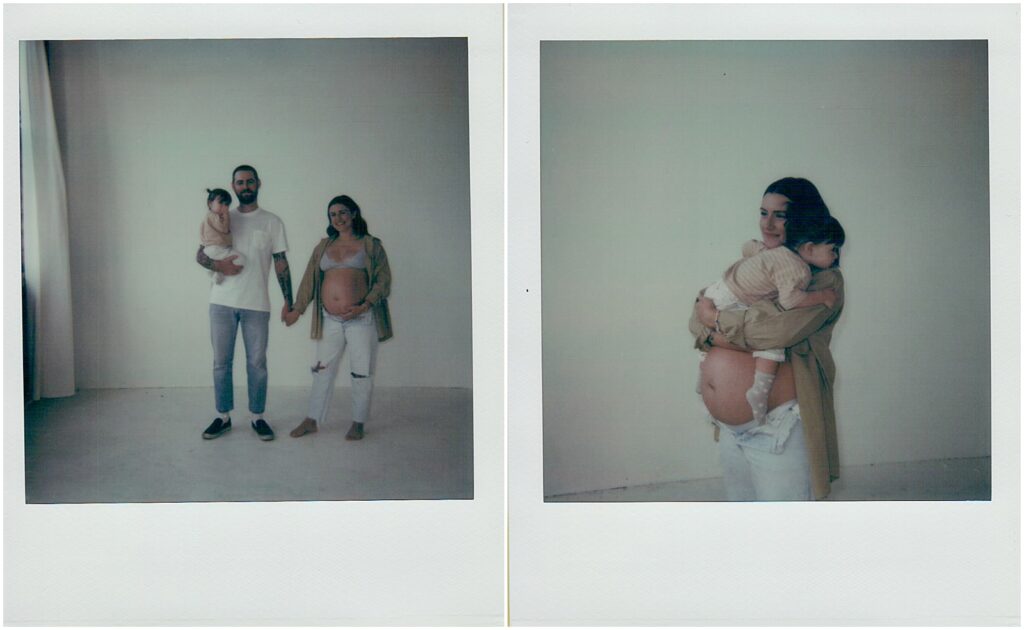 A man holds his toddler and holds his pregnant wife's hand in a Milwaukee studio in film photography.