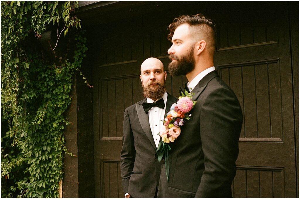 A groomsman looks to a groom in front of a Milwaukee wedding venue.