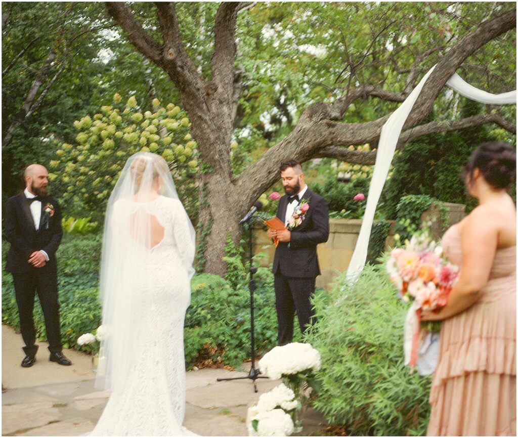 A groom reads his vows at a garden wedding in Oshkosh.