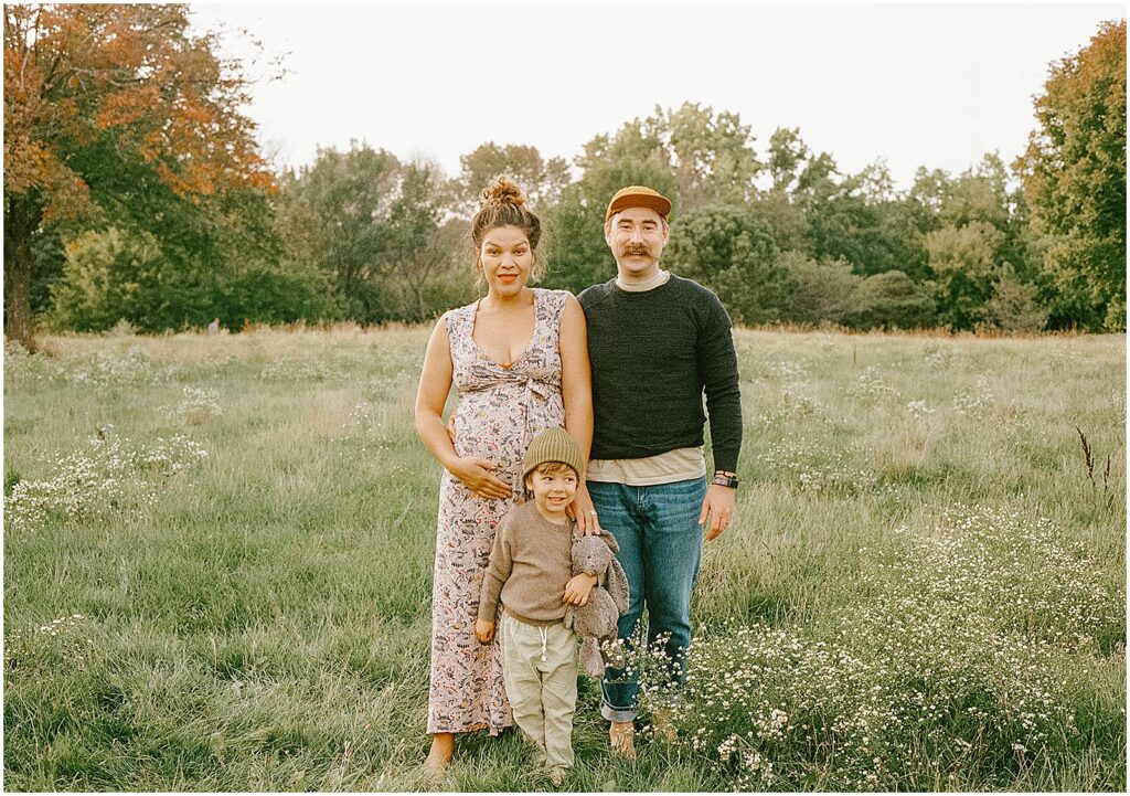 A family poses for a Milwaukee family photographer in a field.