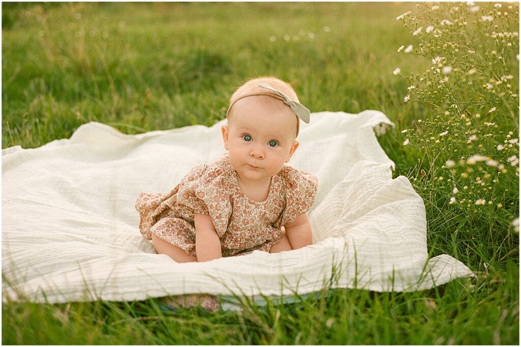 A baby lays on a blanket during a family photography session in Milwaukee.