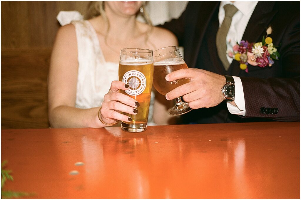 A bride and groom drink beers at a bar counter at Anodyne Coffee.