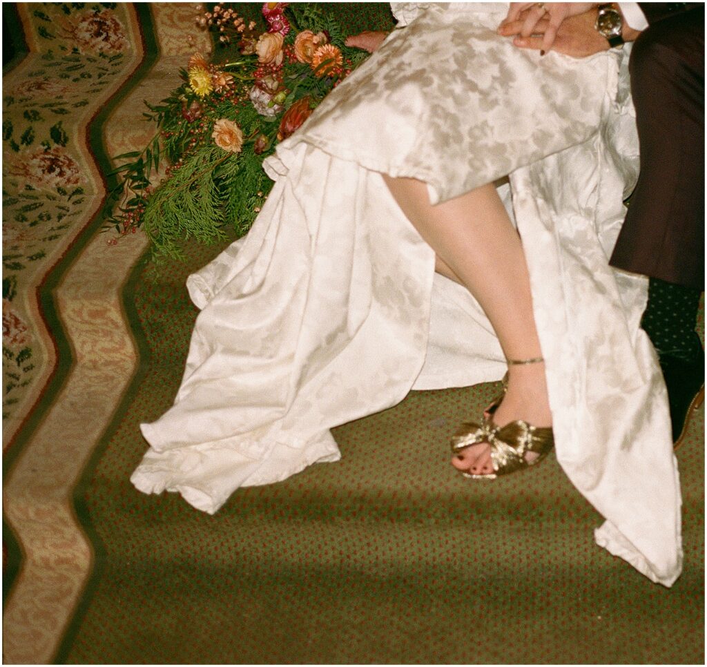 A bride leans against a groom on a staircase in the Pfister Hotel in Milwaukee.