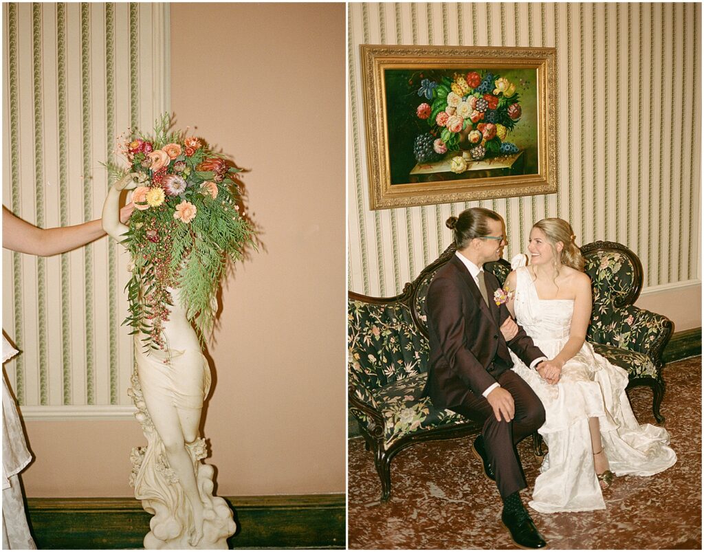 A bride and groom pose for a Milwaukee wedding photographer on a vintage couch in the hallway of the Pfister Hotel.