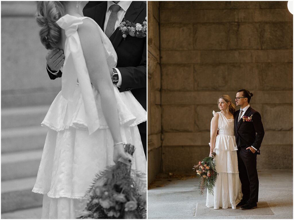 A bride and groom pose in front of a stone wall in downtown Milwaukee.