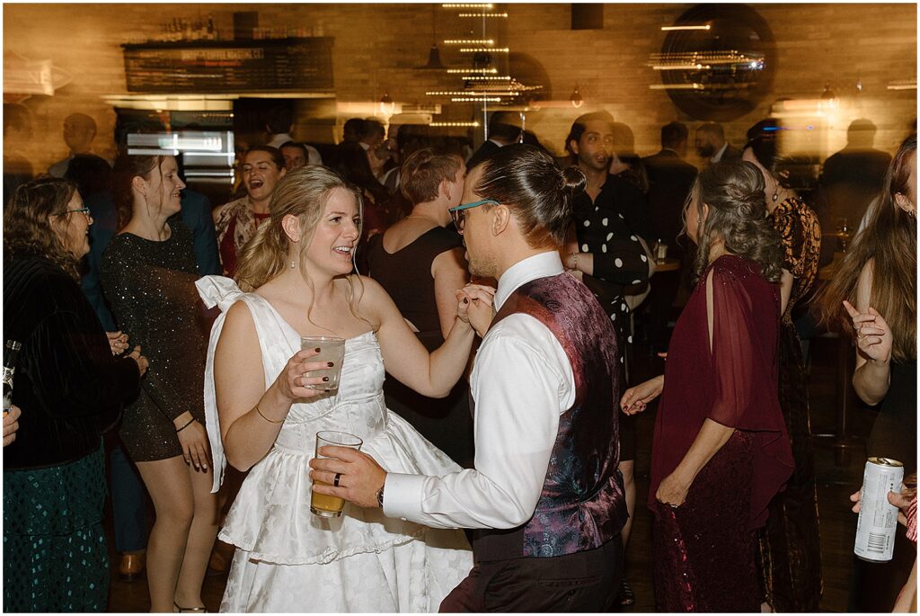 A bride and groom dance surrounded by friends at their Milwaukee wedding reception.