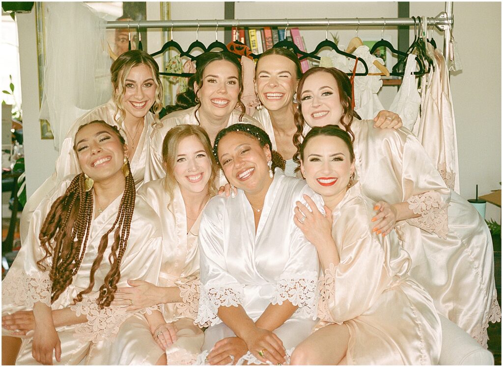 A bride poses with bridesmaids in silk wedding robes for a Milwaukee wedding photographer.