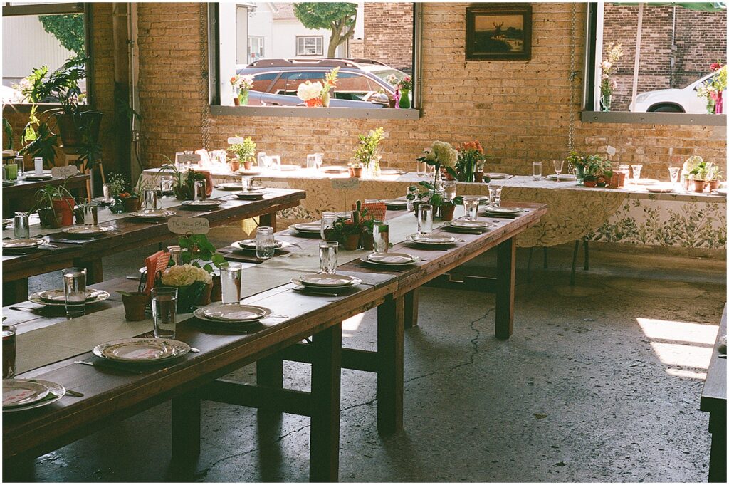 Long tables are set for a reception in a Milwaukee brewery wedding venue.