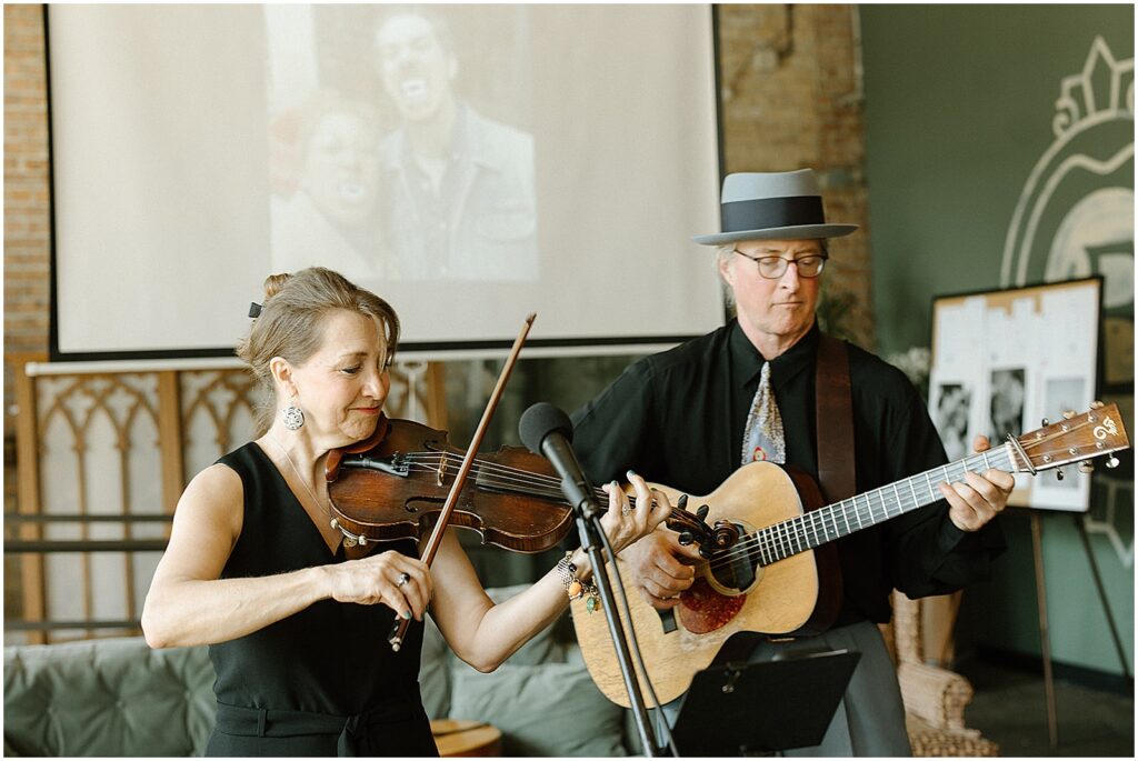 A duo plays violin and guitar for a wedding ceremony.