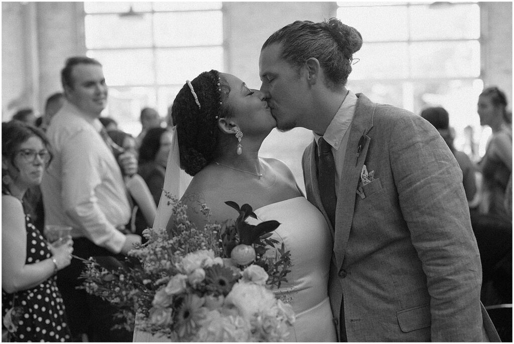 A bride and groom kiss during their recessional.