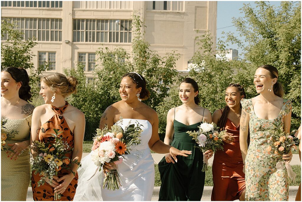 A bride and her bridesmaids walk towards a Milwaukee wedding photographer.