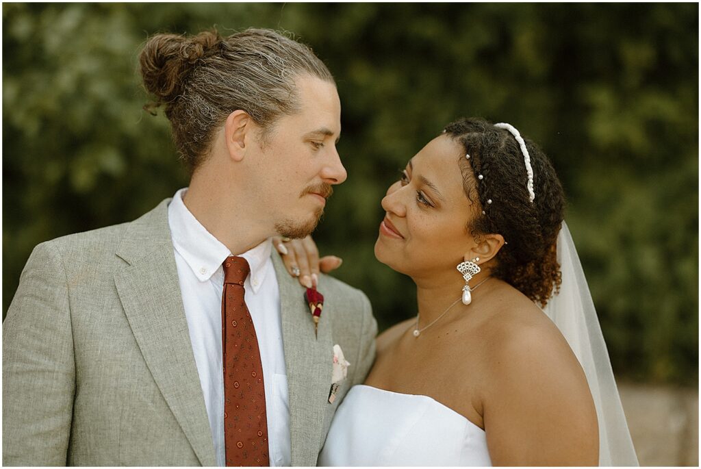 A bride and groom smile at each other after their Milwaukee wedding ceremony.