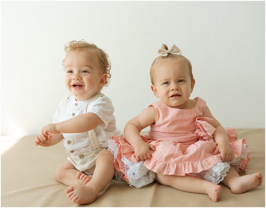 Twin babies smile at a Milwaukee family photographer.