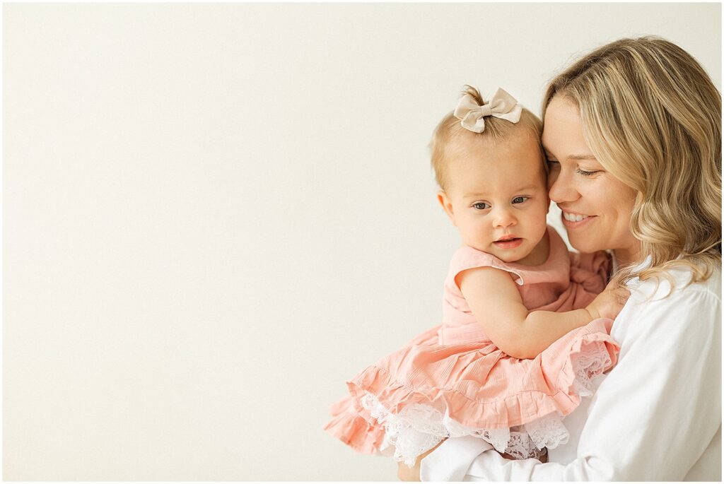 A mother snuggles a baby in a Milwaukee photography studio.