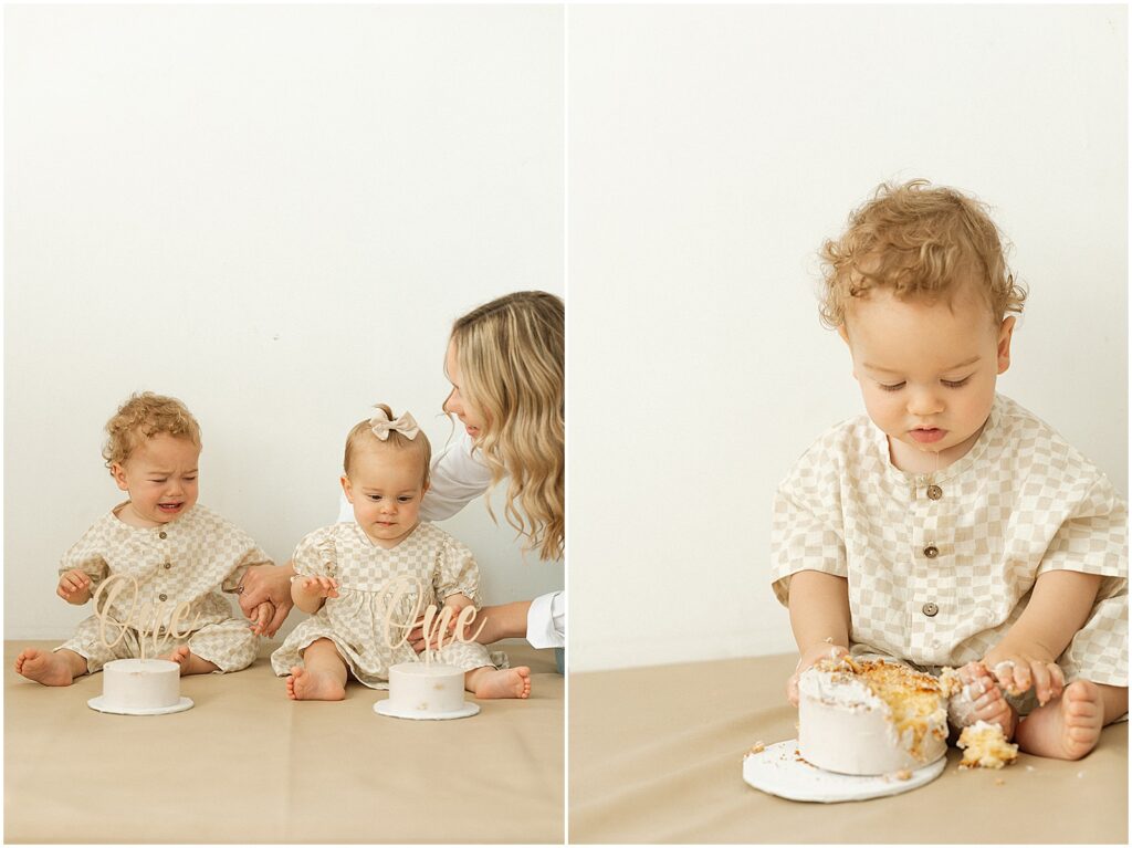 A mother sits small cakes in front of twins for a first birthday cake smash.