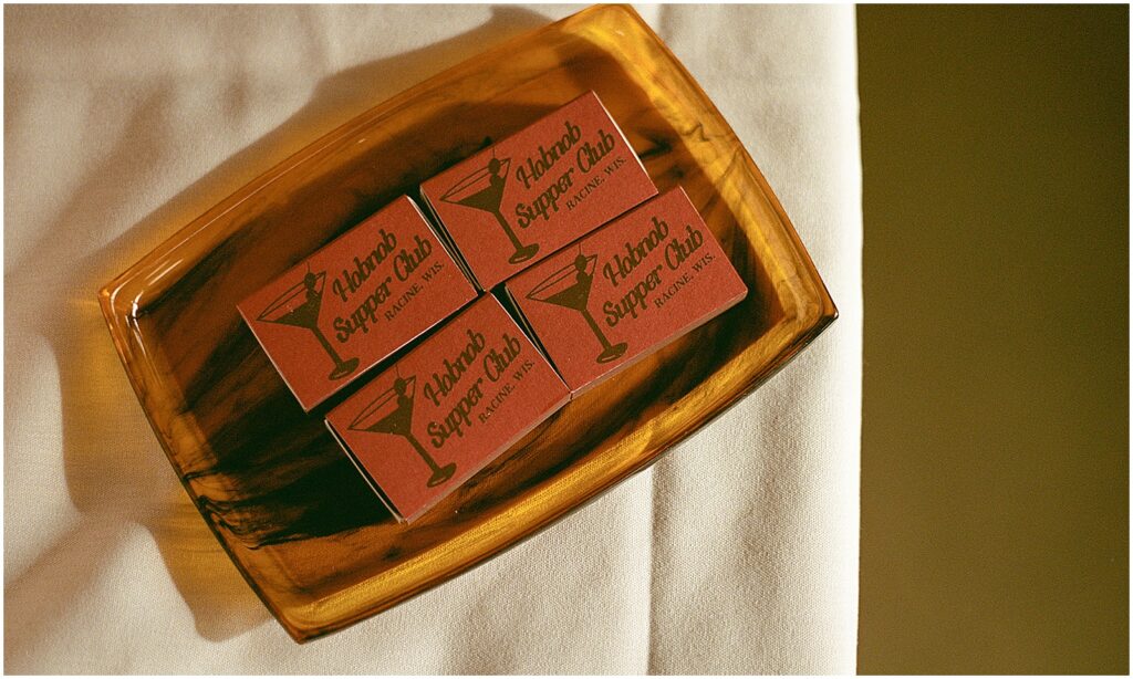 Hobnob Restaurant matchbooks sit in a gold dish on a wedding reception table.