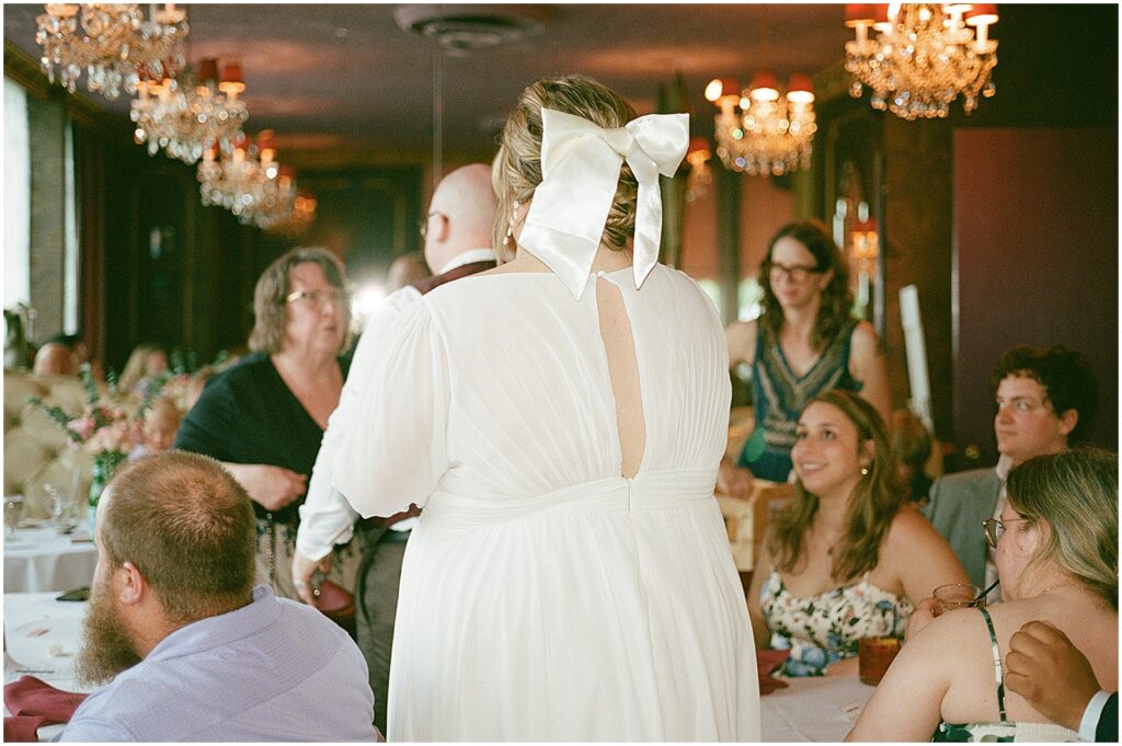 A groom leads a bride into a wedding reception.