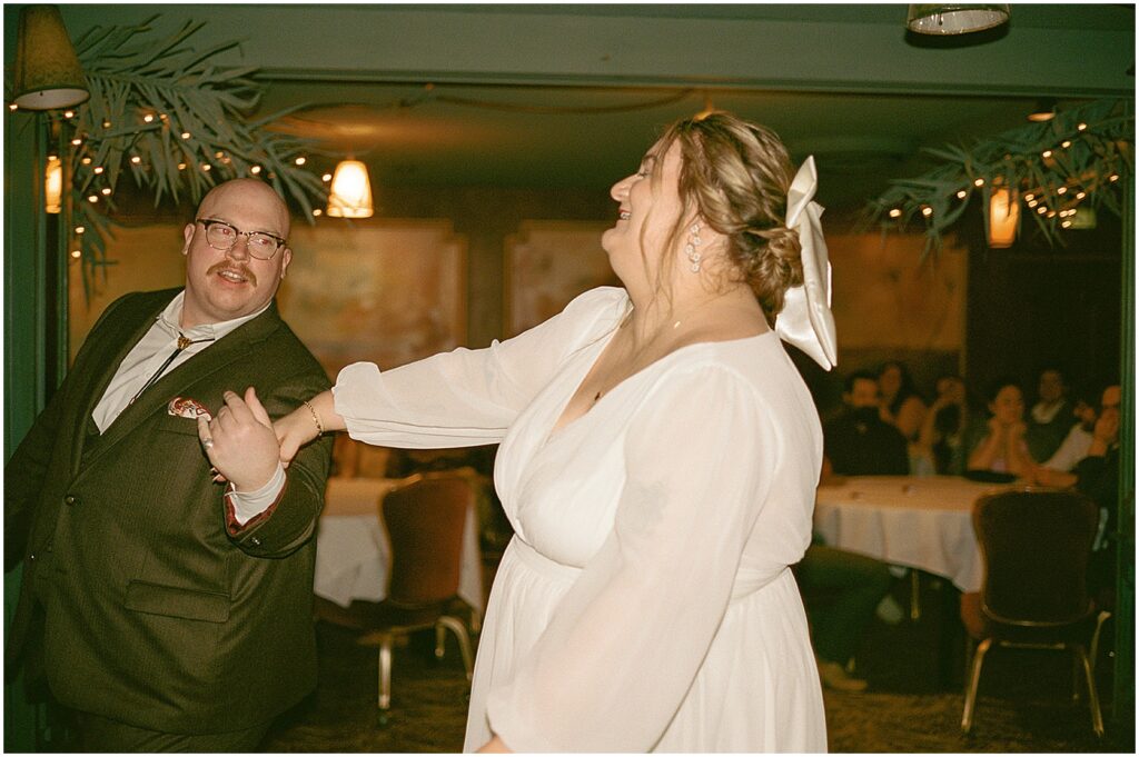 A groom twirls a bride inside a Racine restaurant.