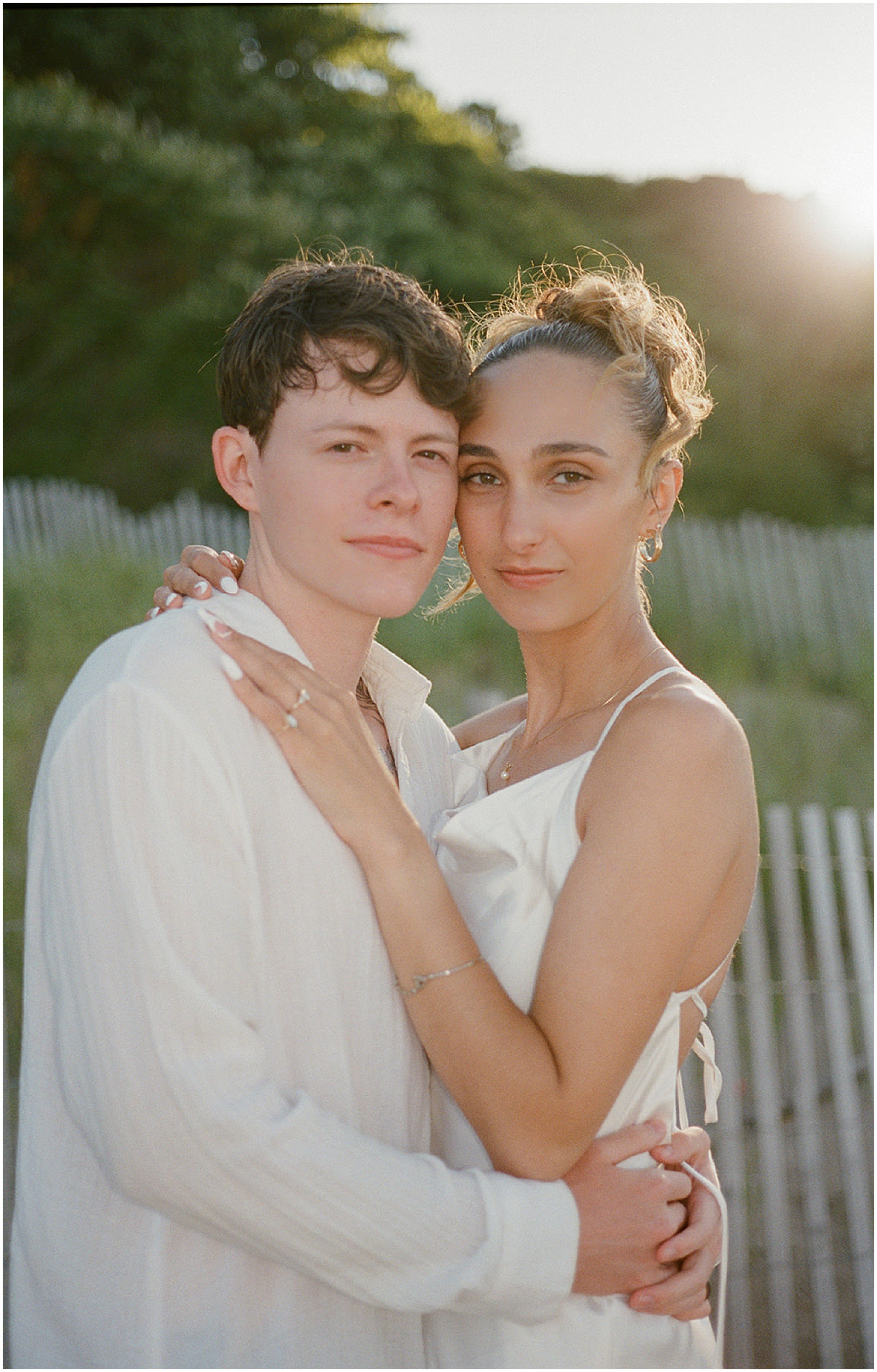 A bride and groom pose for elopement photos on film on a Milwaukee beach.