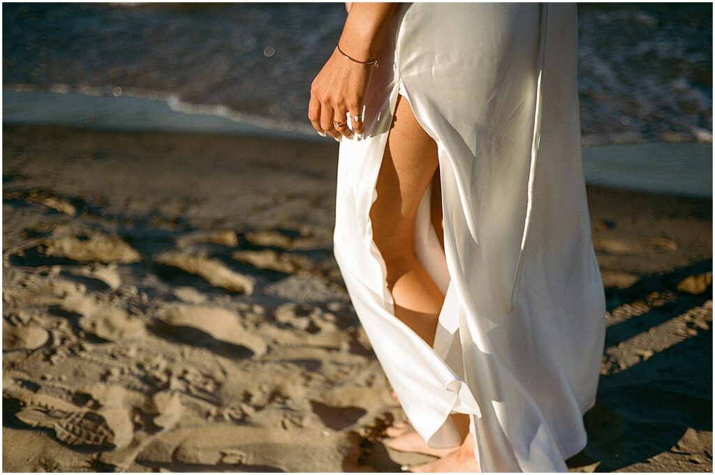 A bride walks along the shore of Lake Michigan in film elopement photos.