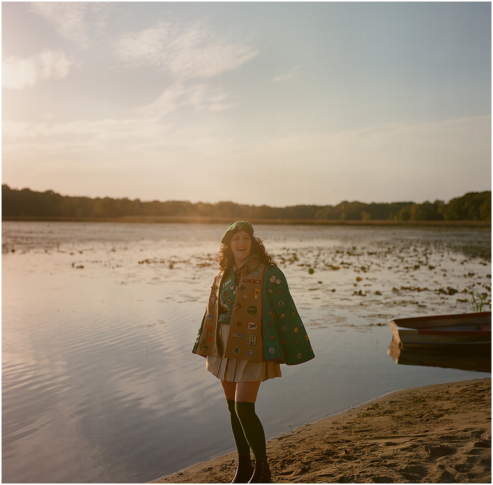 A woman in a scout costume poses for a film photo on the beach at Camp Wandawega.