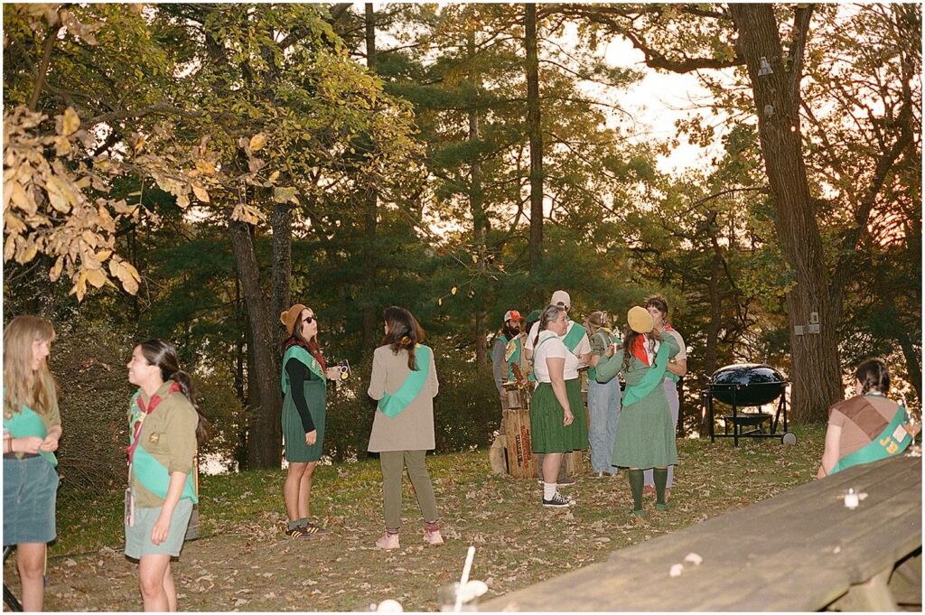 People wearing scout sashes stand around talking at Camp Wandawega.
