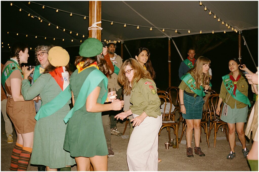Friends dance in a tent during a camp-themed birthday party.