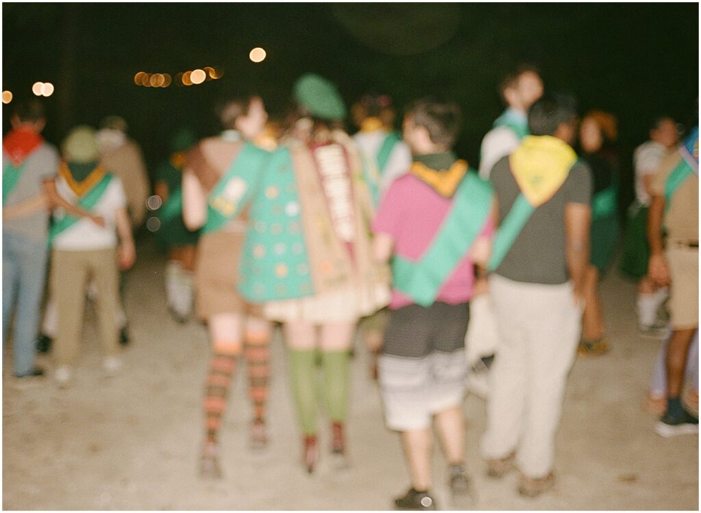 A group of friends dons scout sashes.