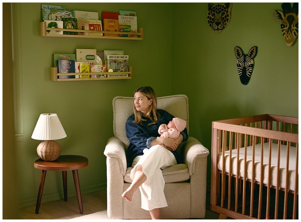 mother sitting in a nursery with her newborn